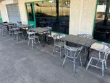 tables and chairs outside of a restaurant that is empty