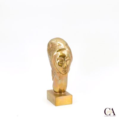 sculpture en or représentant la tête d'une femme, posée sur un socle en or