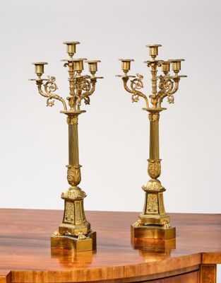 PAIRE DE CANDÉLABRES à quatre feux en laiton ciselé. Les fût…