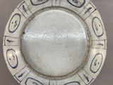 a white plate with blue writing on it sitting on a table