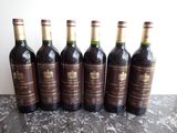 six bottles of wine are lined up in a row on a table