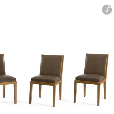 three brown leather dining chairs sitting next to each other on a white surface