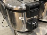 two stainless steel pots sitting on a table in a kitchen