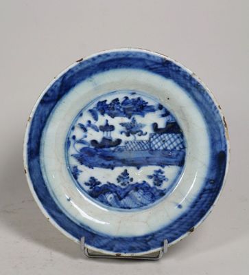 une assiette bleue et blanche sur laquelle est représenté un bateau