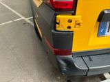 a yellow van parked in a parking lot next to a parking meter