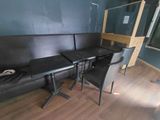une table noire et deux chaises dans un coin de la pièce