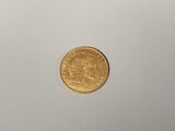 a close up of a gold coin on a white surface