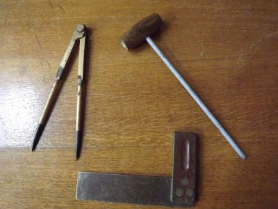 un marteau, un marteau et une paire de ciseaux posés sur une table