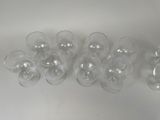 several empty wine glasses are lined up on a white surface