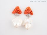paire de boucles d'oreilles en forme de roses orange ornées de perles blanches sur fond blanc