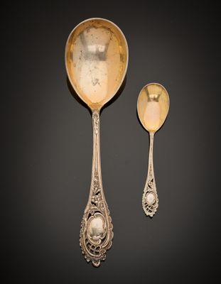 two spoons and a spoon rest on a black surface