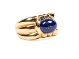un gros plan d'une bague en or sertie d'un lapis-lazuli