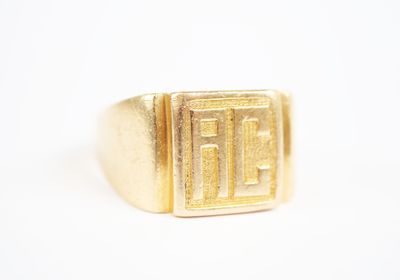 an image of a gold signet ring with the letter f on it