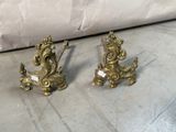 two gold colored candlesticks on the floor next to a couch