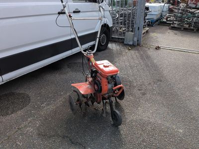 a small red bike parked in front of a white van