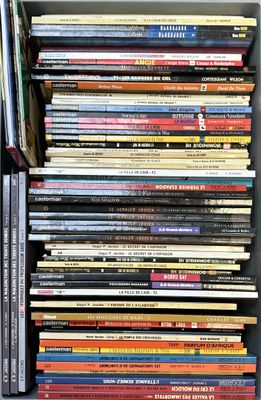 a lot of books that are stacked up on a shelf