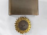 une horloge accrochée au mur, sur laquelle est représenté un tournesol