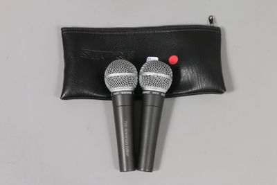 two microphones in a black pouch on a white surface