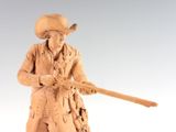 a statue of a man with a rifle and a hat
