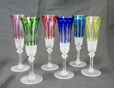 six multicolored wine glasses are lined up in a row