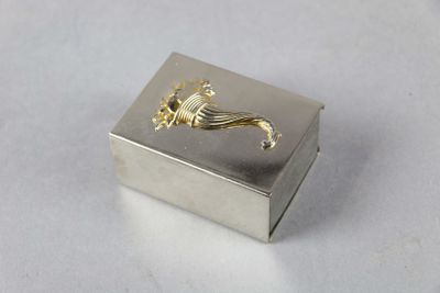 une petite boîte en argent ornée d'un motif doré