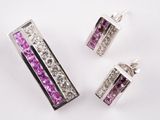 trois bijoux en cristal violet et blanc posés sur une surface blanche