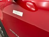 a close up of a red car with a sticker on it
