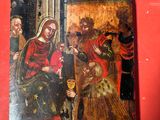 un vieux tableau représentant la Vierge à l'Enfant est posé sur un fond rouge