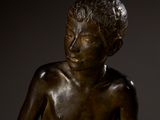 bronze statue of a boy holding a bird in his hands