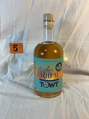 a bottle of liquor sitting on a bed with a price tag