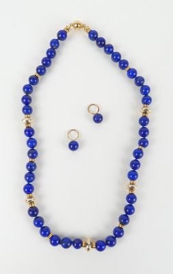 un ensemble composé d'un collier et de boucles d'oreilles en perles bleues sur fond blanc