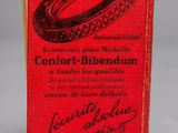 an old book with a red cover sitting on top of a table