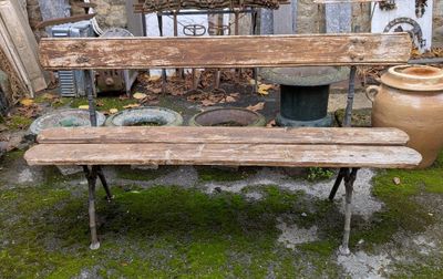un banc en bois posé devant un bâtiment en pierre