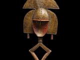 une image représentant un masque en bronze sur fond noir