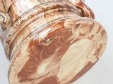 a brown and white vase with a handle on it