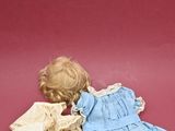 a doll that is laying down on a red surface