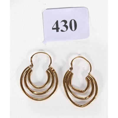 une paire de boucles d'oreilles en or sur fond blanc
