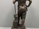 bronze statue of a man with a bucket and a shovel