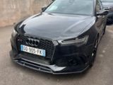 the black audi is parked in a parking lot next to a building