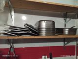 a lot of pots and pans on a shelf in the kitchen