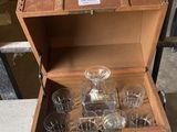 a wooden box with a bottle and glasses inside of it