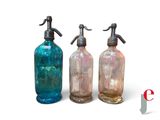 three different colored glass bottles sitting next to each other