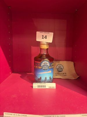 une bouteille d'alcool posée sur une étagère, avec une étiquette de prix