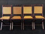 quatre chaises avec des assises en osier et des dossiers en rotin, sur fond noir