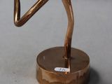 a bronze statue of a man running on a gold base