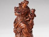 une figurine sculptée représentant une femme tenant un enfant dans ses bras