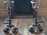 two metal candles that are sitting on wheels on the floor