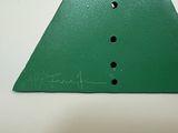 a green triangle with holes in it on a table
