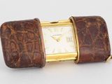 une image représentant une montre avec un bracelet en cuir et un boîtier plaqué or