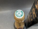 a bottle of beer that is sitting in the sink